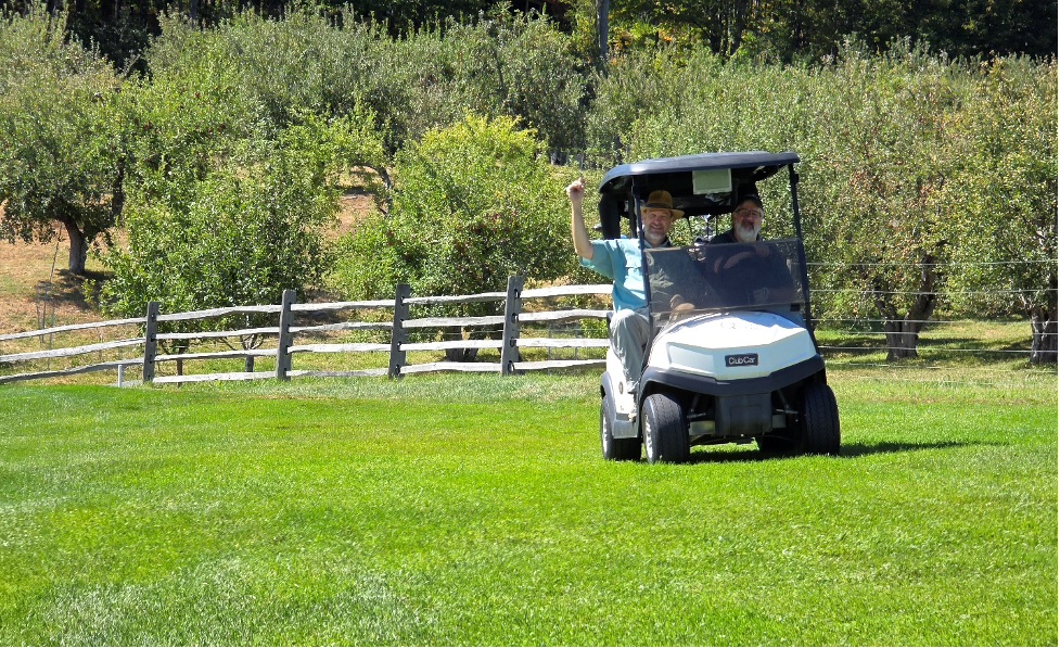 Team Banwell members riding in golf cart in Quechee, Vermont